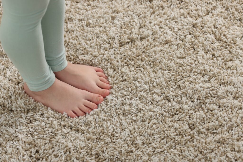 Girl on soft carpet at home, above view. Space for text